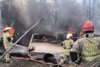 Petugas Pemadam Kebakaran berjibaku memadamkan kobaran api di Gudang penimbunan solar.