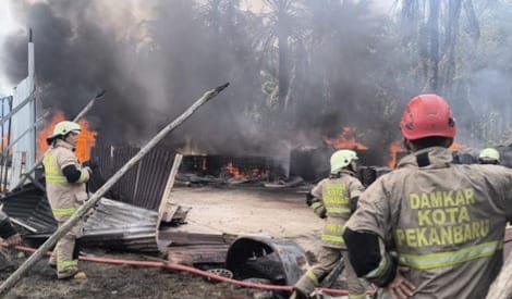 Petugas Pemadam Kebakaran berjibaku memadamkan kobaran api di Gudang penimbunan solar.